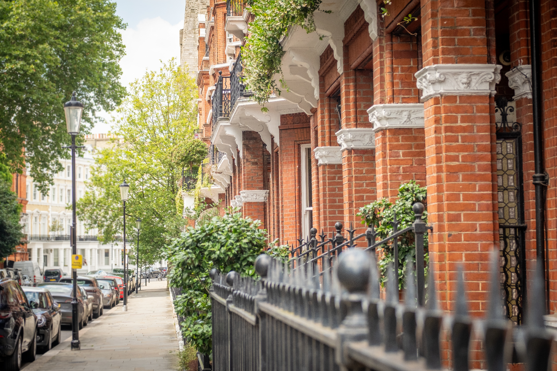 Elegant red-brick London townhouses on a leafy street