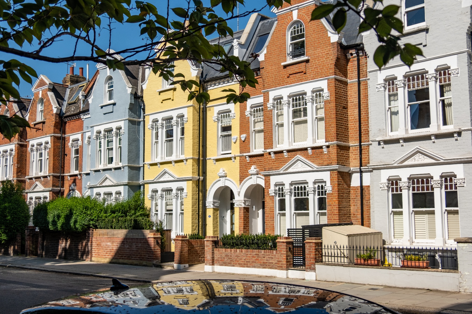 Elegant red-brick London townhouses on a tree-lined street